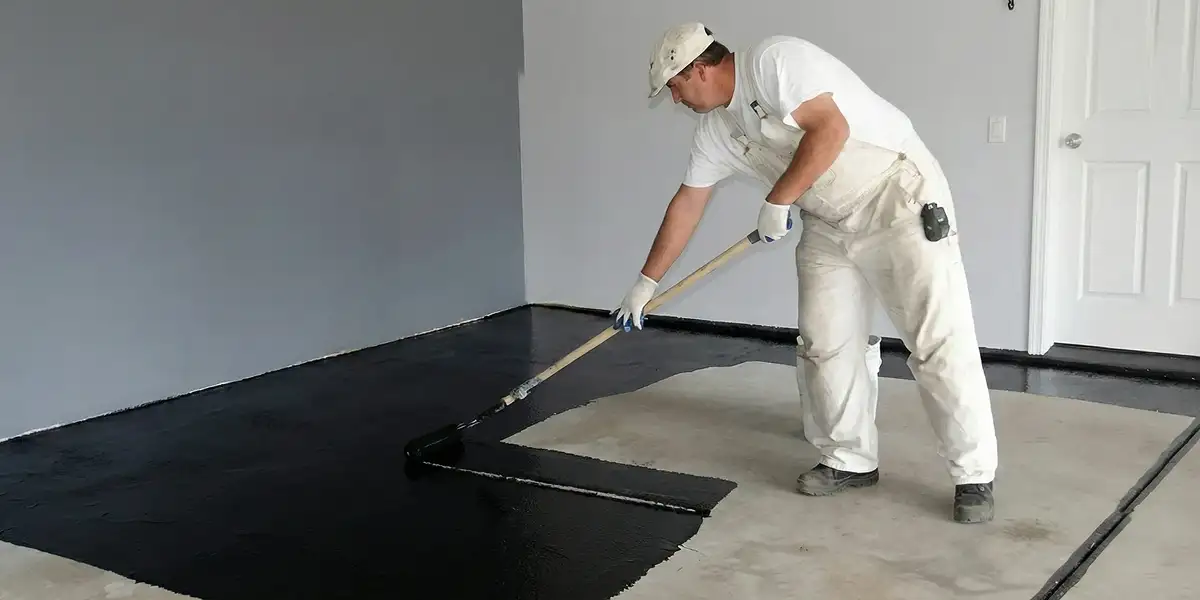 basement waterproofing professional applying waterproof coating to protect a basement floor in Arlington, TX