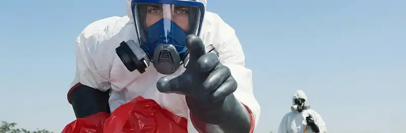 sewage clean up technician wearing protective gear handling biohazard materials in Arlington, TX